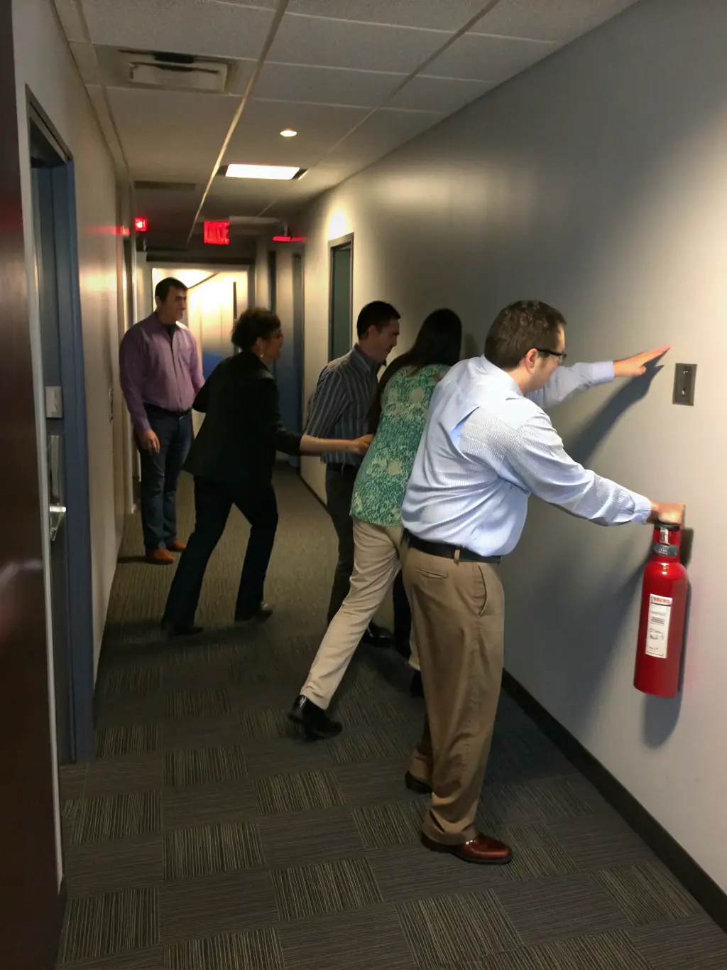 A photo depicting a diverse group of employees participating in an active shooter response training session, focusing on evacuation techniques.
